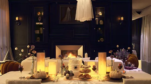 dining room with Halloween-themed decor setting a festive table for dinner with a warm ambiance, incorporating a cozy fireplace, showcasing interior decor ideas, utilizing Homestyler's 3D rendering feature for realistic design previews.